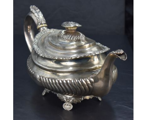 A George III silver teapot, of moulded oval form with foliate embossed finial topped, domed and gadrooned cover with ivory ri