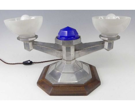 An American Art Deco cast aluminium mounted twin light bracket, having plastic domed shades, of faceted stepped and stylised 