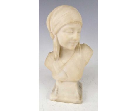 A French Art Deco carved alabaster head and shoulders bust, modelled as a young woman wearing a headscarf, raised on integral