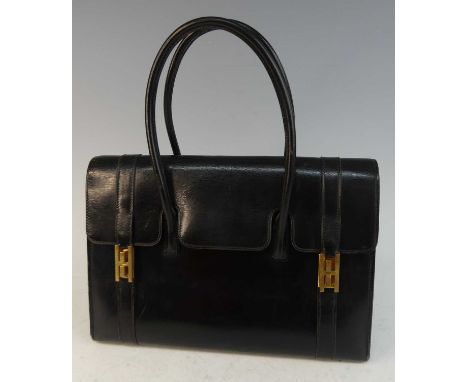 A Hermès black leather drag-up handbag, believed circa 1980s, having gilt brass hardware and twin strap handles, the interior