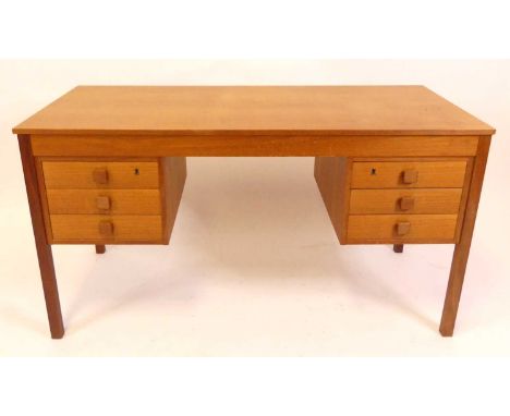 A 1960s Danish teak kneehole writing desk, having a plain top with twin flights of three short drawers, square button shaped 