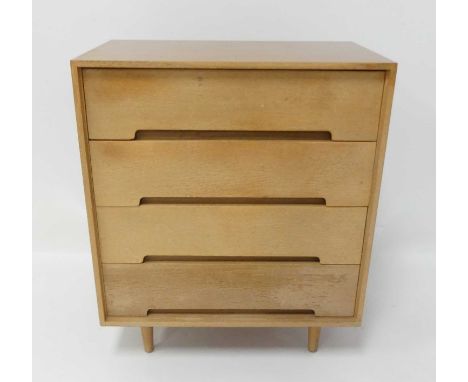 Ernest Gomme for G-Plan - a 1960s light oak chest of four long drawers, having curved integral lower handles, raised on turne