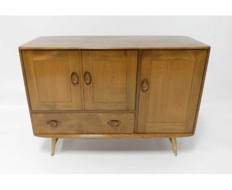 A 1960s Ercol blond elm Windsor 366 compact sideboard, having an arrangement of three cupboard doors and single lower drawer,