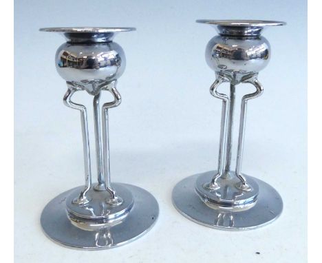 A pair of Art Nouveau silver candlesticks, each with bulbous sconce on wired shaped triform supports, to circular stepped fla