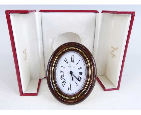 Must de Cartier - a Pendulette travel alarm clock, having a signed oval white enamel Roman dial within deep tan coloured enam