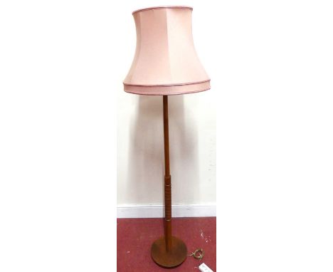 A 1960s probably G-Plan teak standard lamp, with turned colum to grid lower detail, on circular base, h.136cm (excluding fitt