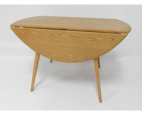 A 1960s Ercol blond elm Windsor 384 dropflap kitchen table, having opposing fall leaves, raised on slightly curved tapering s