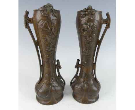 A pair of French Art Nouveau patinated spelter vases, each with twin shaped and stepped handles, with raised opposing floral 