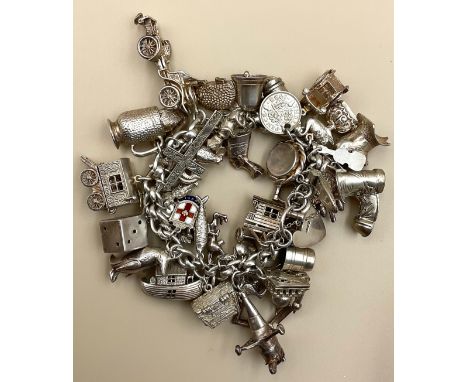 A silver charm bracelet,full of hallmarked silver and unmarked white metal charms to include two gypsy wagons, a cuckoo clock
