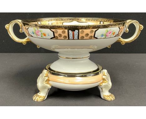 A Japanese Noritake pedestal two handled dish on stand, the base resting on three lion paw feet, printed and painted with pin