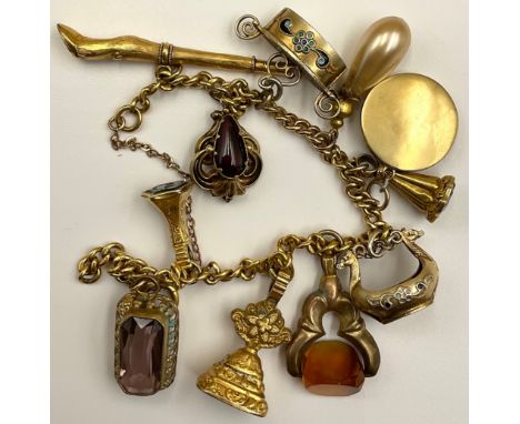 An 18ct gold curb link charm bracelet full of charms, to include tested 9ct gold charms such as the bloodstone watch fob seal