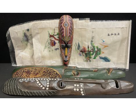 A large carved tribal style wall mask, painted in monochrome, 98cm; another smaller, brightly painted, 49cm; another, 99cm; a
