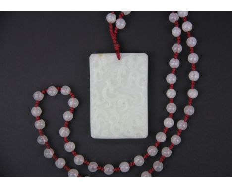 A Chinese carved nephrite jade amulet with crystal bead cord, amulet size 6.5 x 4.5 x 4.1cm.