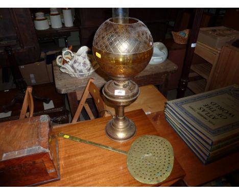A brass oil lamp converted to electricity; together with a 19th Century brass skimmer 