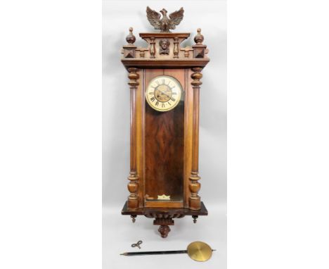 A Vienna style wall clock, late 19th century, the walnut case with carved ornament, the twin train movement striking on a gon