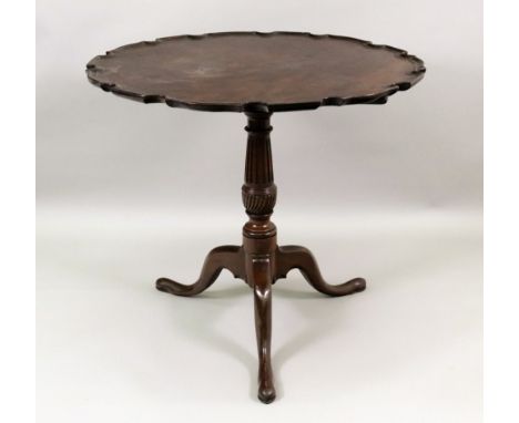 A Chippendale style mahogany tea table, George III and later, the shaped circular moulded edge tilt-top on a fluted and whorl