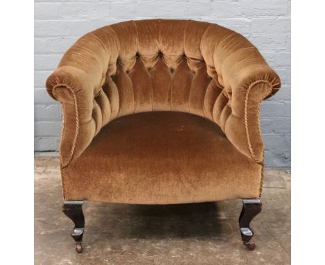 An Edwardian button down upholstered tub back armchair on cabriole legs.