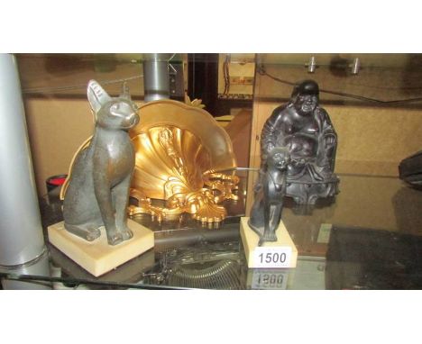 A Buddha, two Egyptian cats and a gilded wall bracket.