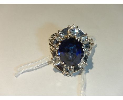 An 18ct white gold ring set large sapphire surrounded by 8 small diamonds, size N.  (total weight 8.3 grams).*CONDITION REPOR