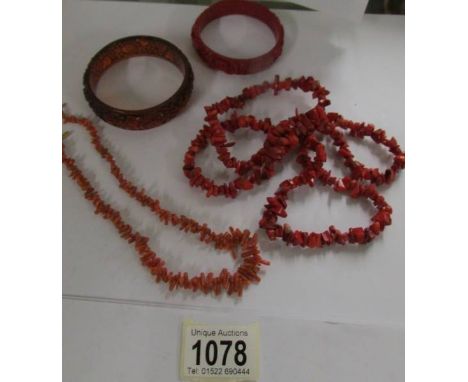 A red coral necklace, a pink coral necklace, two bangles and a similar ring.