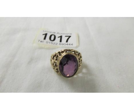 A 9ct gold ring set large amethyst coloured stone, size ). 8 grams.