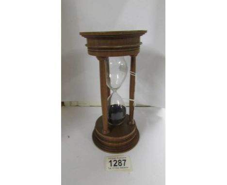 A David Linley walnut timer with stepped base with 3 columns, charcoal coloured sand and a silver hall marked plaque marked L