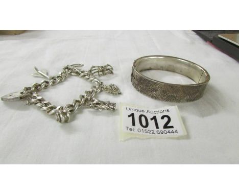 A silver bangle and a silver charm bracelet. 65 grams.