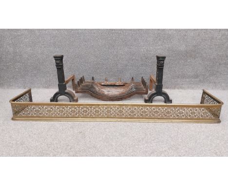 A pierced brass fire kerb, along with a cast iron fire grate, and a pair of cast iron fire dogs of fluted pilaster form on sh