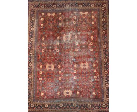 A large Shirvan carpet with stylised flowerhead motifs across the burgundy field within multiple foliate borders. L.415 W.314