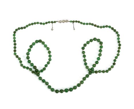 A graduated jade necklace, the apple green beads measure from 4.5mm to 8.5mm, held by an 18ct white gold diamond clasp set wi