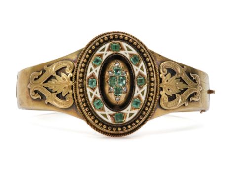 A Continental Neo-Etruscan 14/15ct enamel, diamond and emerald bangle. The bangle set with an oval motif set with four emeral