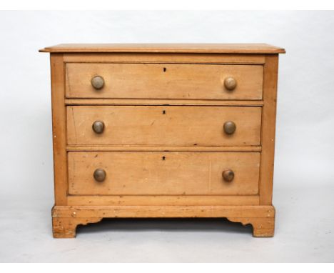 A Georgian pine chest of drawers, bevelled rectangular top, over three graduating drawers, panelled sides, on carved bracket 