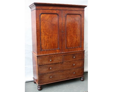 A Victorian mahogany linen press two cupboards over an arrangement of four drawers with later handles raised on ball feet, 14