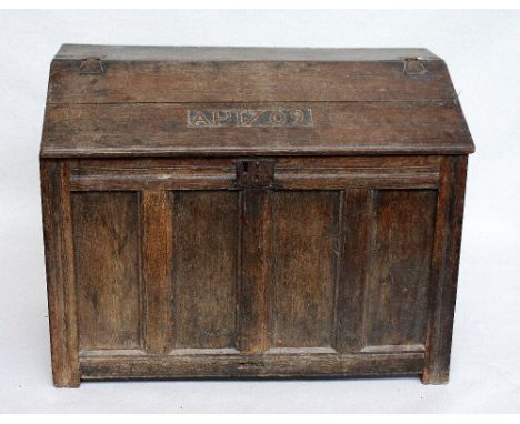 An unusual Queen Anne oak bureau/coffer, the hinged rectangular top carved AP 1709, enclosing three elm drawers above a panel