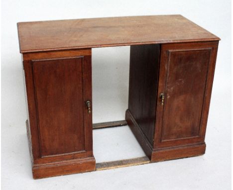 An Edwardian walnut kneehole desk, with rectangular top above two cupboard doors, enclosing drawers, 104cmW