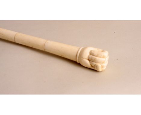 A carved bone sectional swagger stick, the terminal in the form of a clenched fist, 87cm