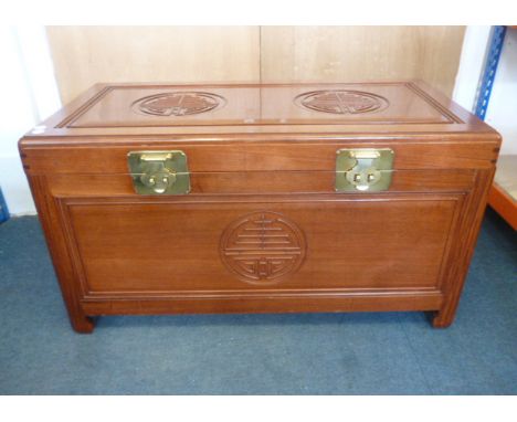 A Chinese camphor wood trunk, the moulded oblong rising top with decoration of two roundels over conforming moulded sides bel