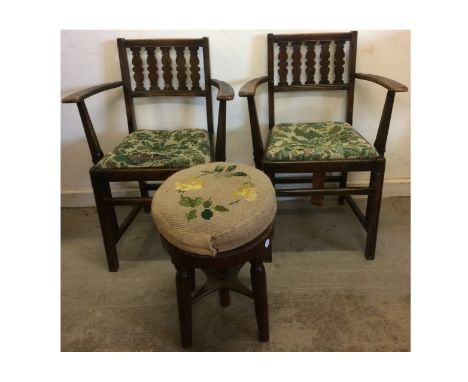 A pair of Ercol arm chairs, stained wood with drop in seats of tapestry upholstery, both with Ercol labels to underside, toge