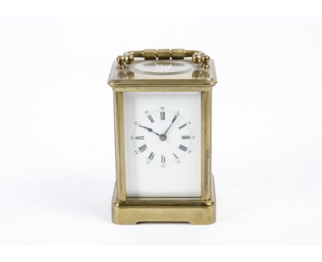 An Early 20th Century carriage clock, white enamel dial with Roman numerals, a brass case with handle and an exhibition case 