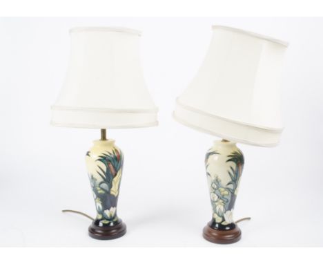 A pair of contemporary Moorcroft ceramic lamp bases, of shouldered form decorated in the Lamia pattern on turned wooden stand