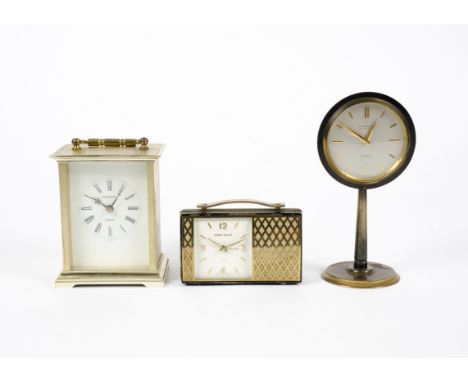 Two timepieces or 'carriage clocks',  designed in the form of a radio with gilt and black lacquer metal, white enamel dial wi