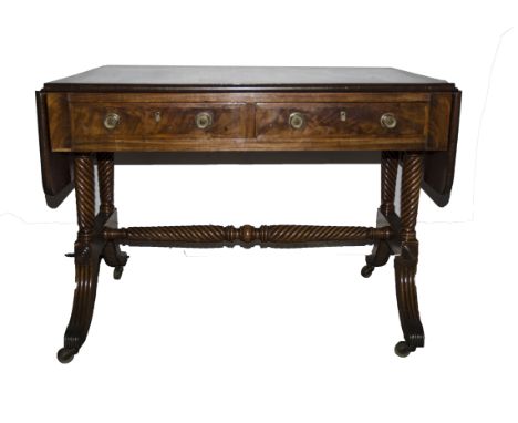 An English Regency mahogany and rosewood cross banded sofa table, the oblong flat top with rounded corners over a pair of fri