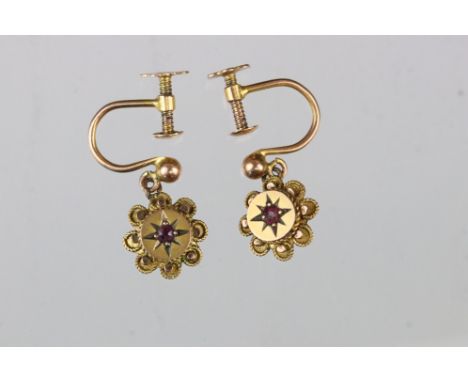 Pair of Victorian/ Edwardian ruby 9ct yellow gold drop earrings, small round cut ruby, gypsy set, flower head surround, screw
