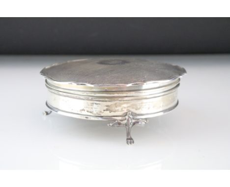 Silver trinket box, the circular body raised on three feet, reeded hinged lid with initialled cartouche, pie crust border, si