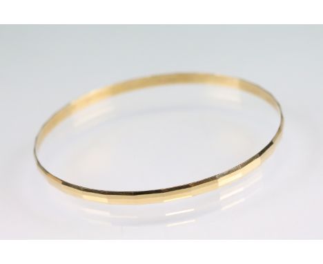 18ct yellow gold bangle, faceted design, width approx 3.5mm, interior diameter approx 20.5cm 