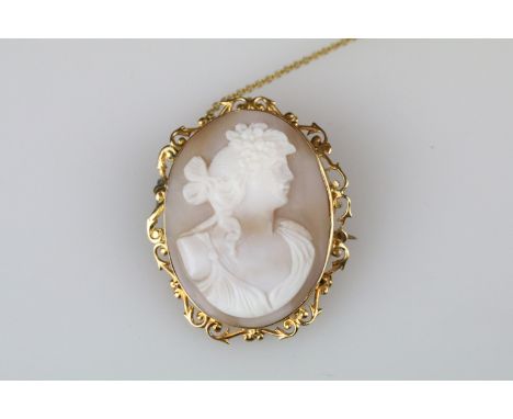 Shell cameo 9ct yellow gold brooch, the female profile facing right, rubover set with openwork scroll surround, dimensions ap