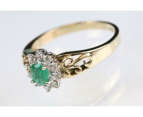 Emerald and diamond 9ct yellow and white gold flower head cluster ring, the oval mixed cut emerald measuring approx 4.5 x 4mm