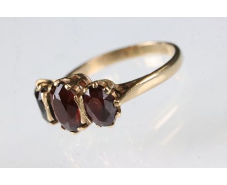 Garnet 9ct yellow gold ring, three oval mixed cut garnets, the principal garnet measuring approx 7.5 x 6mm, claw set, ring si