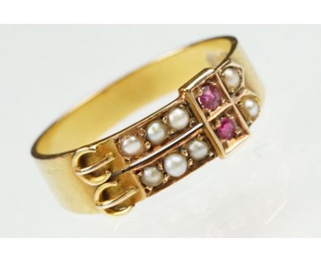 Late 19th century pearl and ruby 15ct yellow gold buckle ring, two rows each set with five seed pearls, two small round mixed