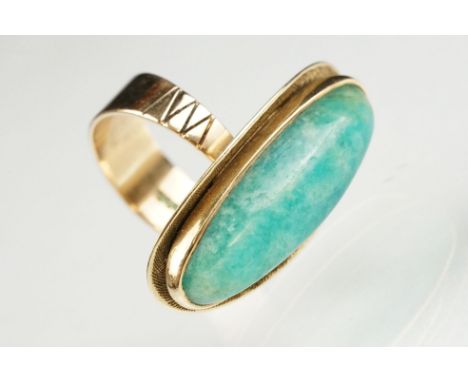 Green hardstone 9ct yellow gold ring, the elongated oval cabochon possibly aventurine quartz, rubover set, textured surround,